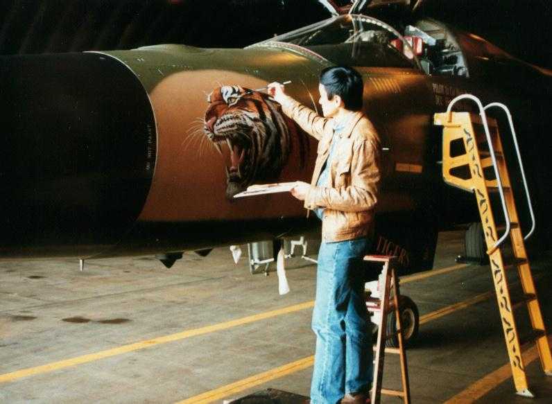 Ronald Wong painting the nose of a F-111